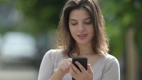 Young Happy Beautiful Woman Using Phone in the Streets Outdoors