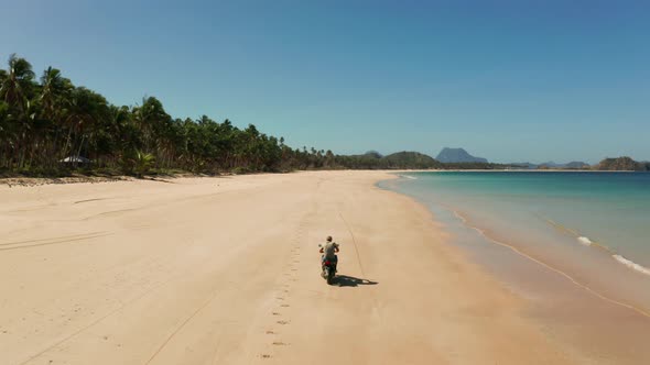 Man Driving a Motorcycle on Beach.