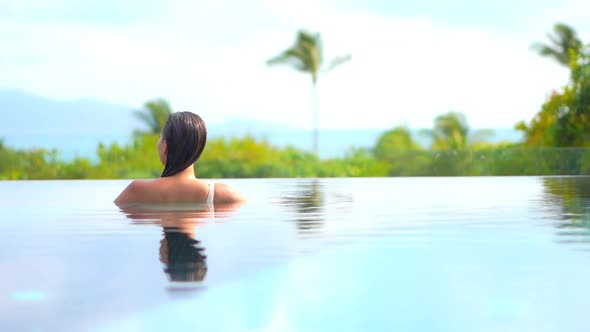 Young asian woman enjoy around outdoor swimming pool for leisure