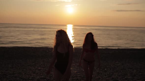 Happy Lesbian Couple Run Holding Hands Each Other at Beach Watching Sunset