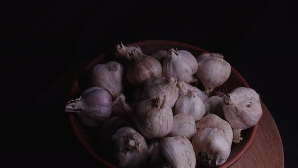 Pile of Whole Bulbs of Garlic in Ceramic Bowl on Table