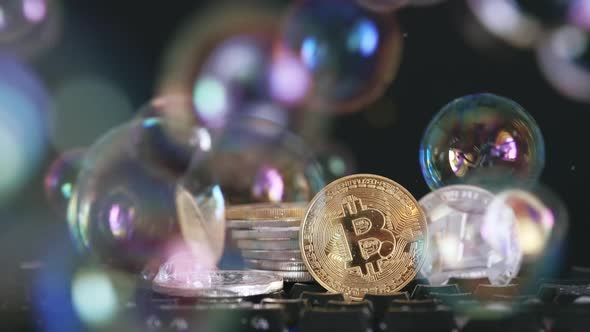Cryptocurrency Bitcoin and Litecoin on a Black Background with Flying Soap Bubbles