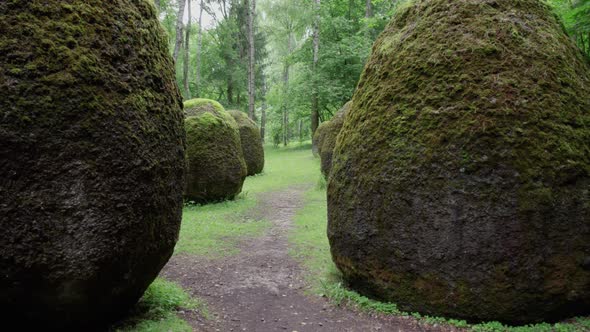 slow drone overflight rocks in the form of huge eggs overgrown with moss Europe park near Vilnius Li