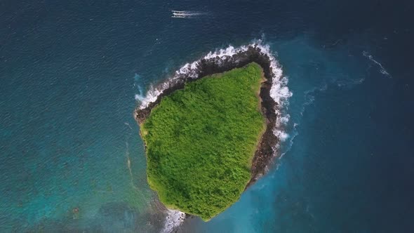 Drone View Over a Small Islet Full of Green Lush with Waves Crashing on Rocks.