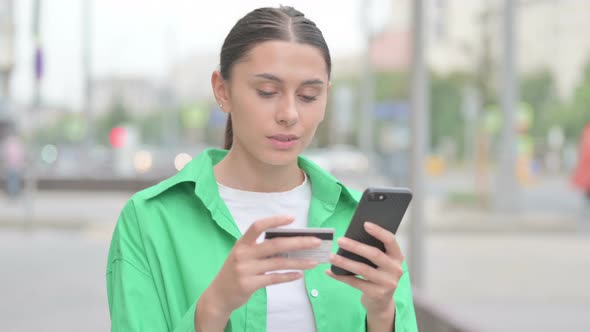 Excited Hispanic Woman Shopping Online on Smartphone Outdoor