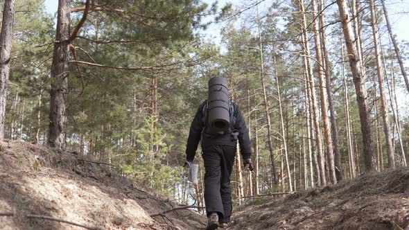 Orienteering in the forest. Tourist on a hike in a forest park with a map.