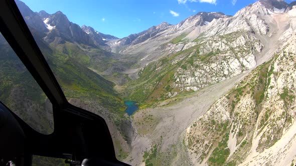 View From the Helicopter Cockpit Over Rocky Mountains and Lake