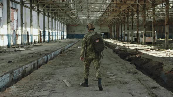 Back View of Soldier From American Forces on Old Plant