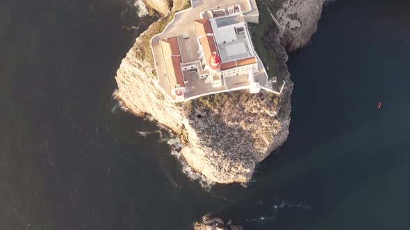 Tilt up aerial view of Cabo de Sao Vicente lighthouse overlooking the ocean,  Sagres, Algarve