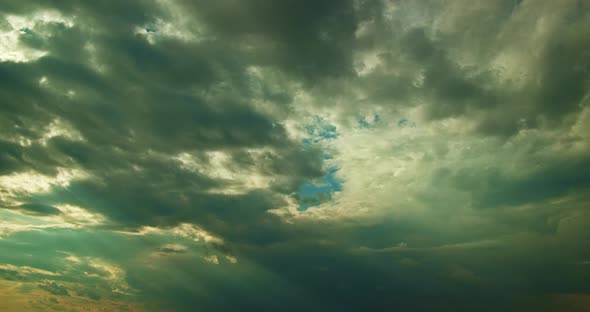 Time Lapse of Sun Rays Breaking Through Thick Gray Cumulus Moving Clouds