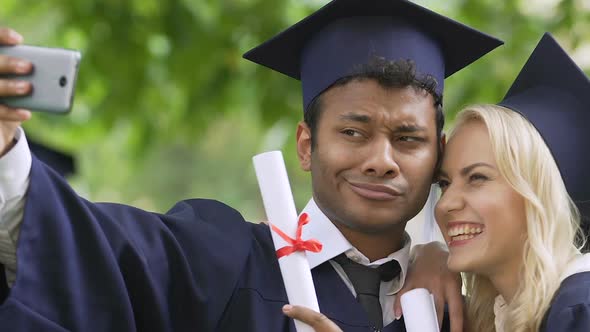 Cheerful Multiethnic Students Posing, Making Selfie in Graduation Academic Gown