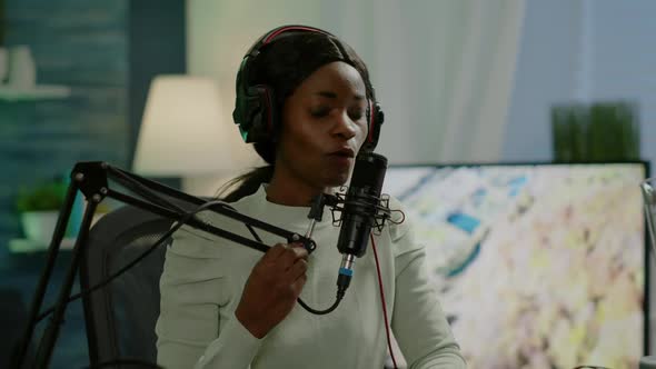 African Woman Host of Online Show Talking Into Microphone