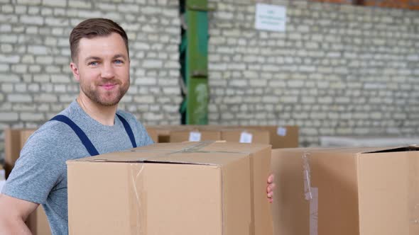 Warehouse Employee Collects an Order Taking Cardboard Boxes and Parcels From the Shelf