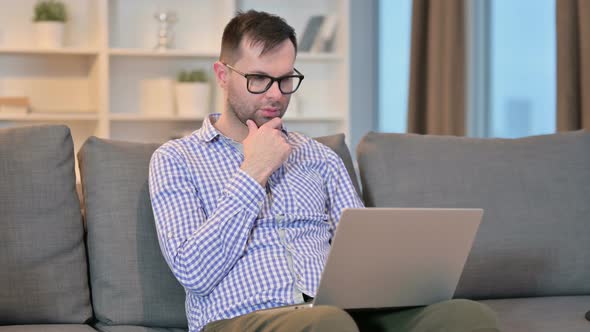 Hardworking Man Thinking and Working on Laptop at Home 