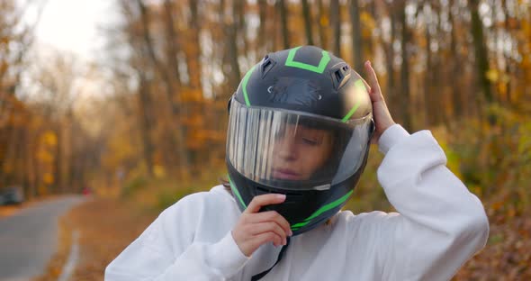 Closeup of a Girl in White Wears a Protective Helmet on His Head Sitting on an ATV in the Autumn