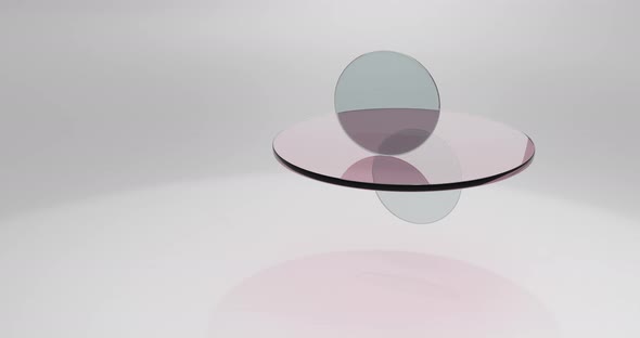 Translucent round glass lenses spinning and rotating on white background. Abstract background