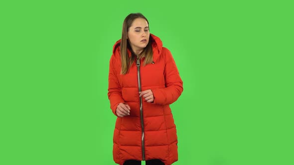 Lovely Girl in a Red Down Jacket Is Frightened Then Sighs with Relief and Smiling. Green Screen