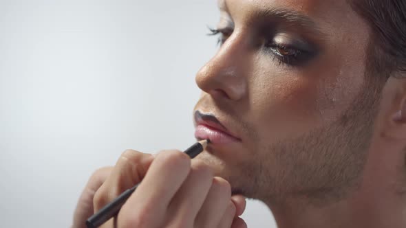 Applying Black Lip Liner on Handsome Man