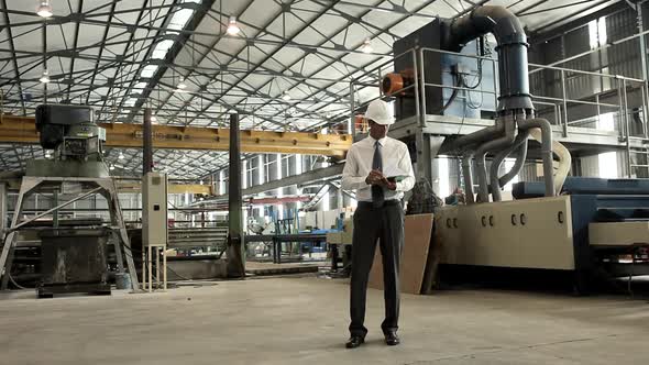 Mature Man with Clipboard in Factory