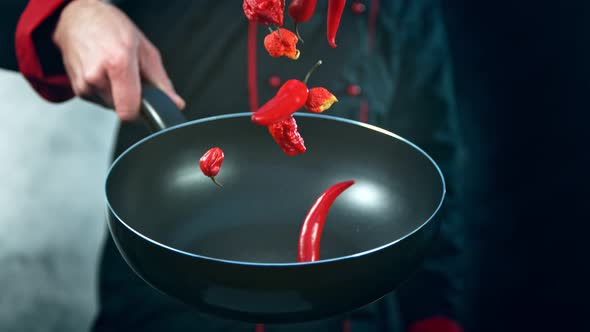 Super Slow Motion Shot of Chef Holding Frying Pan and Falling Chilli Peppers at 1000Fps