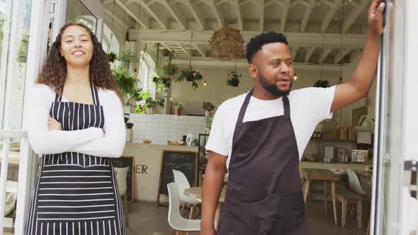 Portrait of happy african american male cafe owner and biracial female barista at cafe