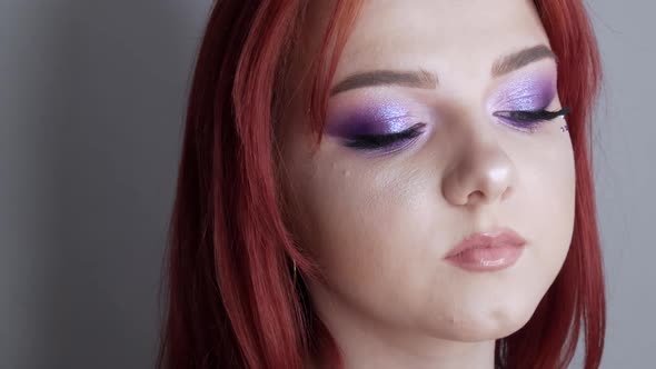 Closeup View of Beautiful Young Girl Model with Bright Red Hair and Purple Makeup Posing in the