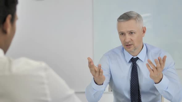 Angry Grey Hair Businessman Having Argument with Partner at Work