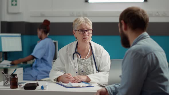 Senior Doctor Writing Consultation Information on Checkup Report