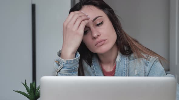 Worried Millennial Female Face Looking at Laptop in Office