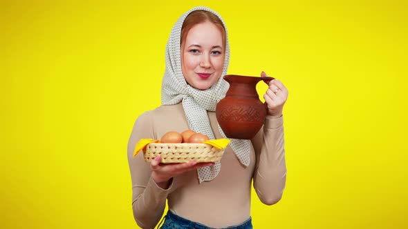 Slim Gorgeous Young Farmer Posing with Eggs and Milk at Yellow Background