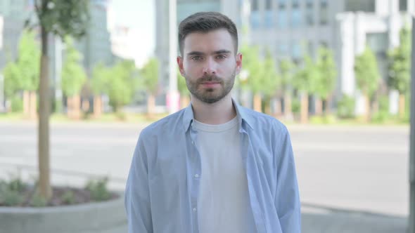 Outdoor Portrait of Young Man Looking at the Camera