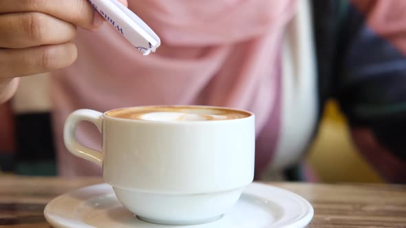 Person Hand Stirring Coffee with Spoon