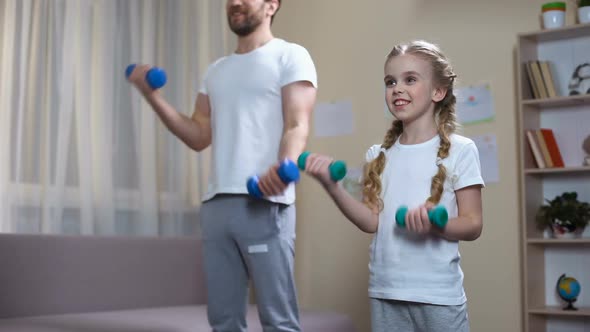 Smiling Schoolgirl Lifting Dumbbells With Father, Home Workout, Sport Education