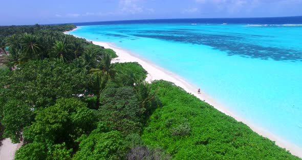 Daytime flying clean view of a sandy white paradise beach and aqua blue water background in best qua
