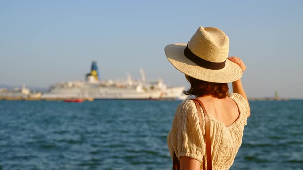 Young woman in hat looking at the sea, video 6k