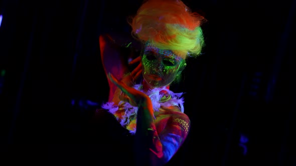 Female Figure Covered Fluorescent Paint is Moving in Darkness Extravagant Image for Halloween or
