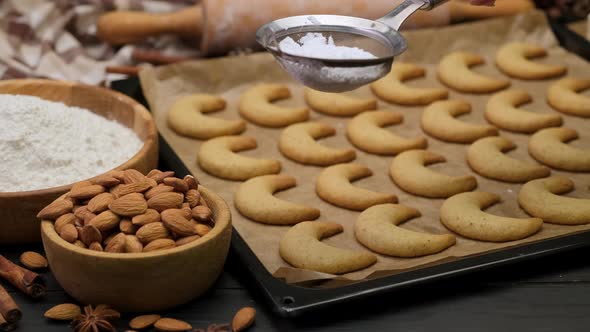 Woman Sprinkles Sugar Powder on Traditional German or Austrian Vanillekipferl Vanilla Kipferl