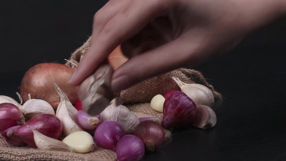 A Hand Placing Some Compound Bulb Of Garlics