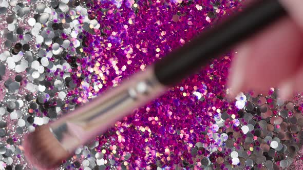 Smearing Silver Glitter on a Pink Background Gloss Powder Closeup