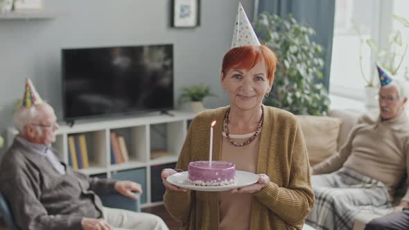 Happy Senior Woman with Birthday Cake