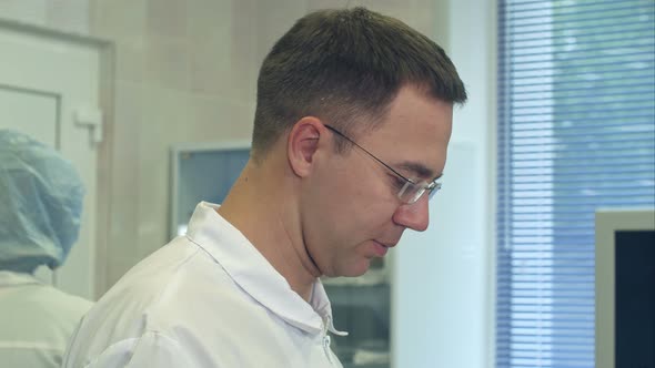 Young Male Doctor Putting Surgical Hat on in a Surgery Room