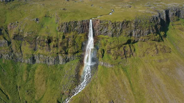 Aerial Drone Footage of Bjarnarfoss Waterfall with Its Green Cliffs in Western Iceland