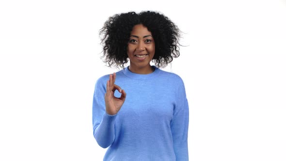 African Woman Showing Ok Sign Over White Studio Background