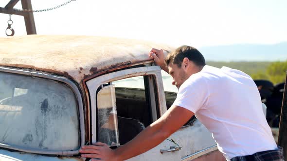 Man examine abandoned car 4k