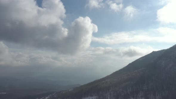 Mountain top in the mist and clouds before sunset 4K aerial video