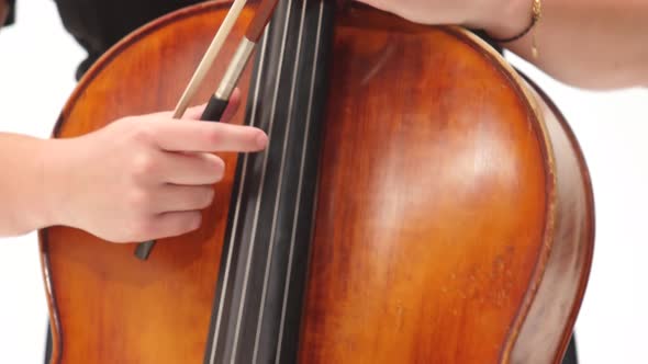 Woman Is Playing the Cello on White Background. Close Up. Steadicam Shot