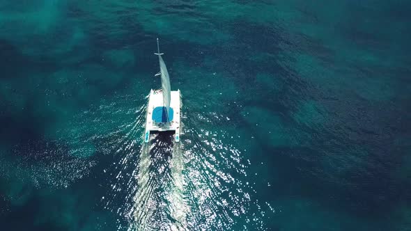drone shoot of the catamaran in the saona island in the caribbean sea with blue water in a sunny day