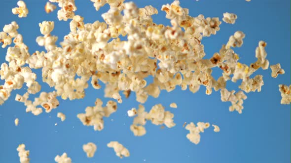 Super Slow Motion Popcorn Takes Off on a Blue Background