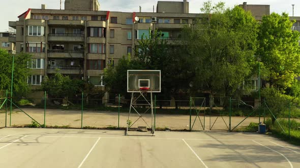 Forward Aerial Footage of Empty Basketball Field in the Neighborhood