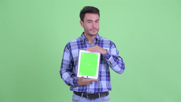 Stressed Young Hispanic Man Showing Digital Tablet
